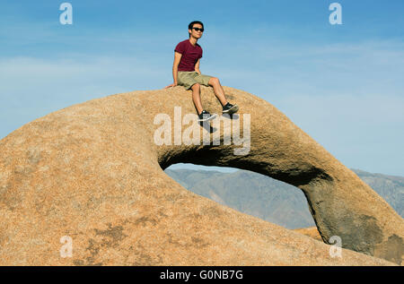 Homme assis sur Arch, Mobius Alabama Hills, Sierra Nevada, en Californie Banque D'Images