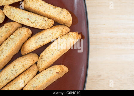 Haut de page Fermer la vue de plusieurs noix amandes biscotti sur une plaque en bois marron au sommet d'une table. Banque D'Images