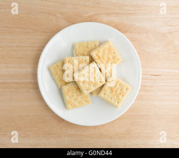 Vue de dessus le fromage à la crème et ciboulette crackers sur une plaque blanche au sommet d'une table en bois. Banque D'Images