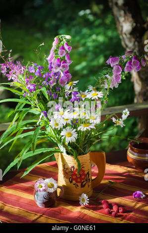 Un bouquet de marguerites dans une cruche à la table Banque D'Images