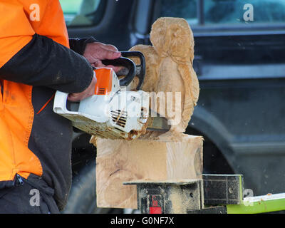 Un homme sculpte sculptures en bois à l'aide d'une scie Banque D'Images