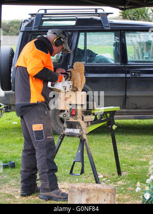 Un homme sculpte sculptures en bois à l'aide d'une scie Banque D'Images