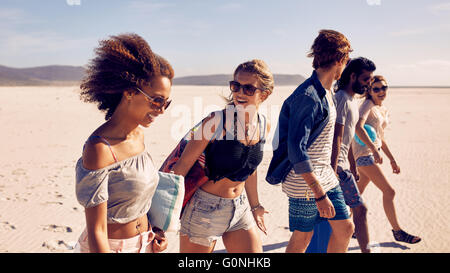 Groupe de jeunes hommes et femmes marchant sur une plage. Divers groupes d'amis sur la plage . Banque D'Images