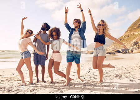 Portrait de jeunes amis debout sur la plage. Groupe multiracial des amis profiter d'une journée à la plage.