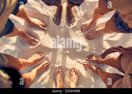 Haut voir l'image de pieds de jeunes debout dans un cercle. Mixed Race friends standing pieds nus sur une plage de sable. Concept de l'uni Banque D'Images