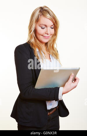 Smiling happy business woman looking at a tablet computer Banque D'Images