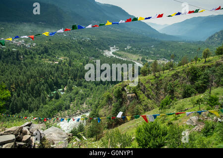 Drapeaux de prière bouddhiste tibétain balancent dans la brise au-dessus de la rivière Bear Valley près de Manali dans l'Himachal Pradesh, Inde Banque D'Images