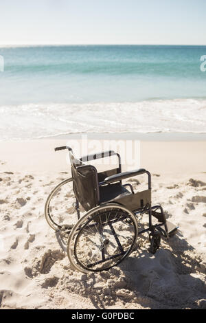 Fauteuil roulant noir sur la plage Banque D'Images