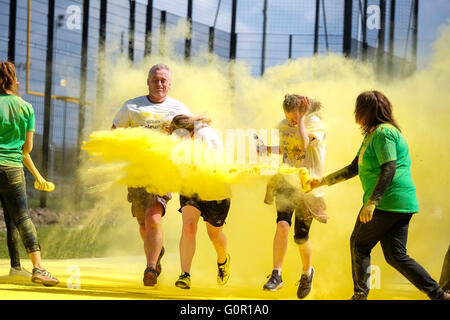 Coureurs prenant part à un organisme de bienfaisance color run à l'université de Central Lancashire à Preston sont fouettés avec poudre de peinture jaune Banque D'Images