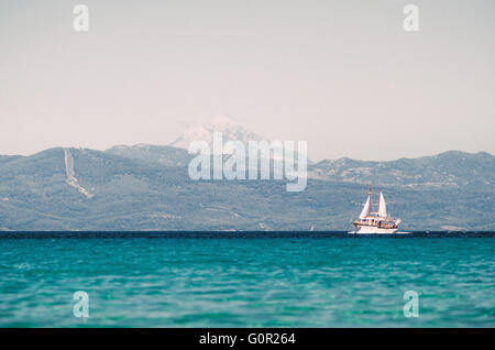 Bateau à voile dans la mer Égée sur l'arrière-plan du mont Athos, la Chalcidique. Banque D'Images