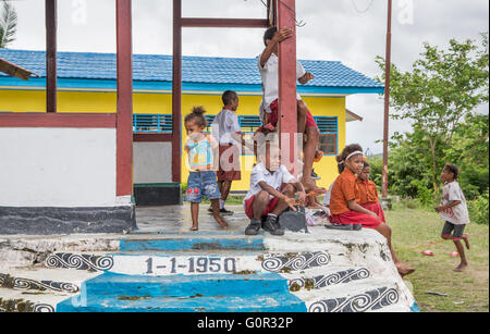 JAYAPURA, en Papouasie occidentale, INDONÉSIE - CIRCA FÉVRIER 2016 : Schoolkids reposant à l'extérieur d'une maison d'école Banque D'Images