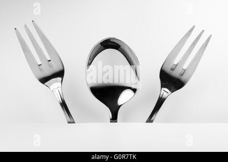 Cuillère en métal et deux fourchettes métal formé dans une figure de fantaisie conceptuelle inquiétant Banque D'Images