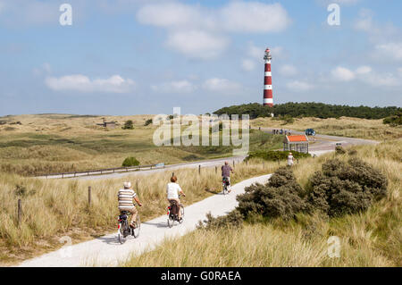 Équitation Les aînés sur les bicyclettes dans les dunes d'Ameland près du phare, Îles des Wadden de Frise, Pays-Bas Banque D'Images