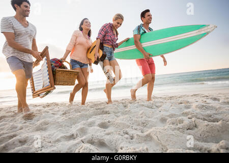 Les amis portant un panier et de surf Banque D'Images