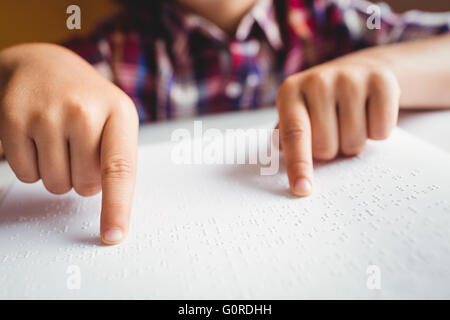 Garçon en utilisant le braille pour lire Banque D'Images