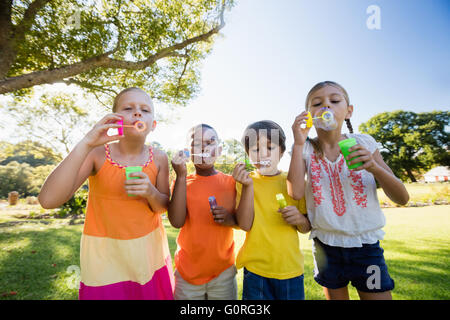 Enfants jouant avec bubble wand dans le parc Banque D'Images