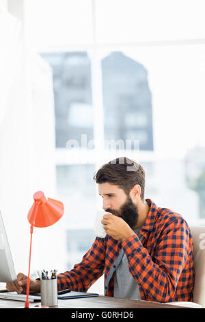 Beau hipster working on computer Banque D'Images