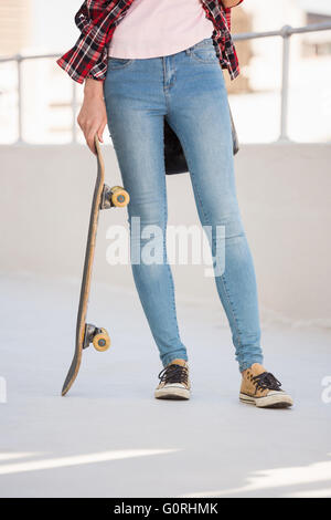 Hipster holding a skateboard Banque D'Images