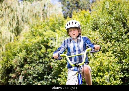 Portrait of boy smiling et riding bike Banque D'Images