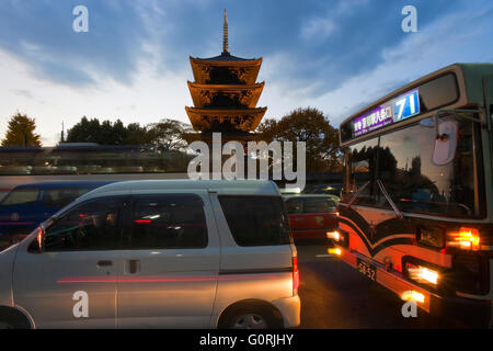 Un crépuscule vue montre la circulation sur l'Avenue Omiya en passant par le Temple Tō-ji pagode à cinq étages en bois (la plus haute tour en bois au Japon), dans le centre de Kyoto, au Japon. Temple Toji est un site du patrimoine mondial. Banque D'Images