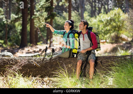 Couple pointing et assis sur un arbre Banque D'Images