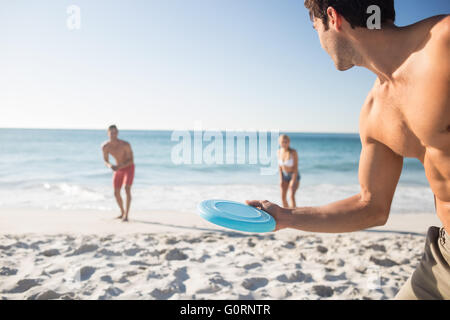 Amis jouant avec un frisbee Banque D'Images