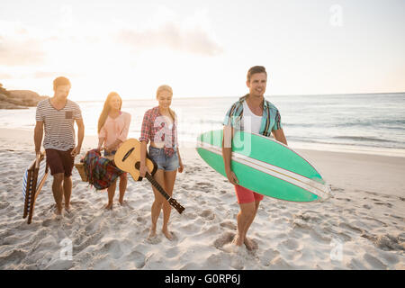 Les amis portant un panier et de surf Banque D'Images