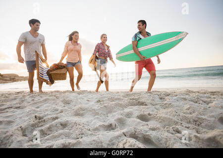 Les amis portant un panier et de surf Banque D'Images