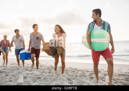 Les amis portant un panier et de surf Banque D'Images