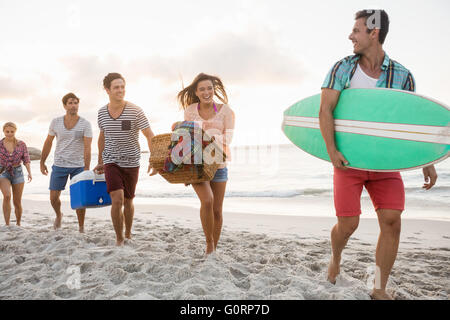 Les amis portant un panier et de surf Banque D'Images