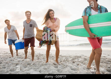 Les amis portant un panier et de surf Banque D'Images