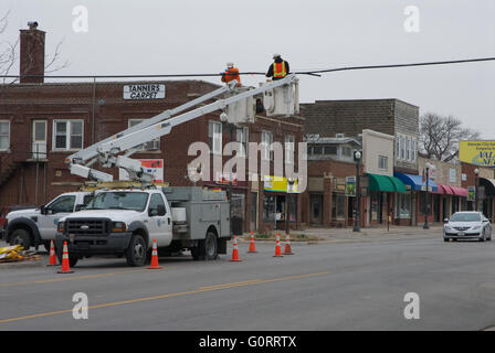 Emporia, Kansas 3-21-2014 Les équipages d'AT&T raccordez pas les câbles de retour ensemble la réparation du dommage causé par un véhicule qui a été surdimensionné de haler un réservoir de stockage du grain de la ferme que le câble téléphonique accroché au plafond tirant et quatre blocs de poteaux de téléphone et d'éclairage de rue le long de la rue commerciale et marchand rue en Emporia. Le camion de Meridian Manufacturing Inc. de Storm Lake dans l'Iowa a été conduite au sud sur la State Route 99, qui est la route pour camions au nord et sud à Emporia pour les gros véhicules qui ne peuvent pas passer sous les ponts sur l'autoroute en raison de la hauteur restricti Banque D'Images