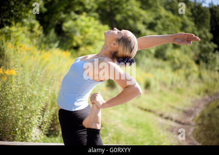 Portrait de jeune femme blonde fit sport sportswear dans l'élaboration de l'extérieur dans le parc de l'été dernier, faisant un tailleur Banque D'Images