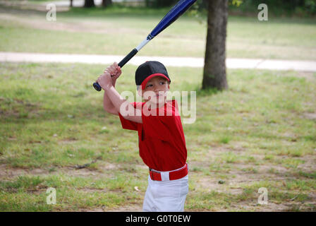 Portrait of Little baseball player holding bat le port de jersey. Banque D'Images