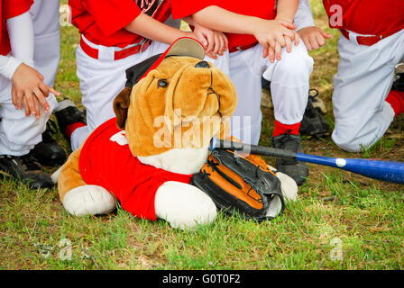 Bulldog peluche habillé en baseball jersey en face de groupe de joueurs. Banque D'Images