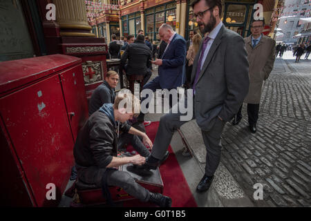 City of London, Londres, Angleterre, Royaume-Uni. 19 avril 2016 Ville types ont leurs chaussures a brillé à l'heure du déjeuner à Leadenhall Market. Leadenhall Market est un marché couvert à Londres, situé sur Gracechurch Street mais avec l'accès des véhicules également disponible via Whittington Avenue au nord et de Lime Street au sud et à l'Est et l'accès des piétons supplémentaires via un certain nombre de passages étroits. Il est l'un des plus anciens marchés de Londres, datant du 14ème siècle, et est situé dans le centre historique de la ville de Londres quartier financier. Banque D'Images