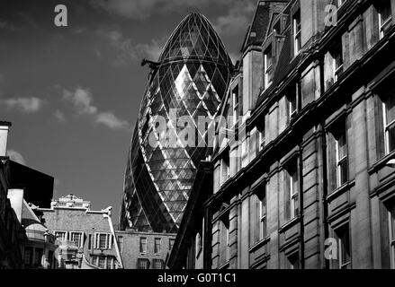 City of London, Londres, Angleterre, Royaume-Uni. 19 avril 2016 30 St Mary Axe (largement connu sous le Gherkin et celles de la Swiss Re Building) est un gratte-ciel commerciaux dans le quartier financier principal, la ville de Londres. Il a été achevé en décembre 2003 et a ouvert ses portes en avril 2004.[4] avec 41 histoires, il est de 180 mètres (591 pi) de hauteur[3] et se tient sur l'ex-sites de la Baltic Exchange et Chamber of Shipping, qui ont subi des dommages en 1992 par l'explosion d'une bombe placée par l'IRA provisoire dans St Mary Axe, la rue à partir de laquelle la towe Banque D'Images