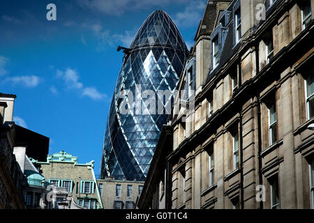 City of London, Londres, Angleterre, Royaume-Uni. 19 avril 2016 30 St Mary Axe (largement connu sous le Gherkin et celles de la Swiss Re Building) est un gratte-ciel commerciaux dans le quartier financier principal, la ville de Londres. Il a été achevé en décembre 2003 et a ouvert ses portes en avril 2004.[4] avec 41 histoires, il est de 180 mètres (591 pi) de hauteur[3] et se tient sur l'ex-sites de la Baltic Exchange et Chamber of Shipping, qui ont subi des dommages en 1992 par l'explosion d'une bombe placée par l'IRA provisoire dans St Mary Axe, la rue à partir de laquelle la towe Banque D'Images