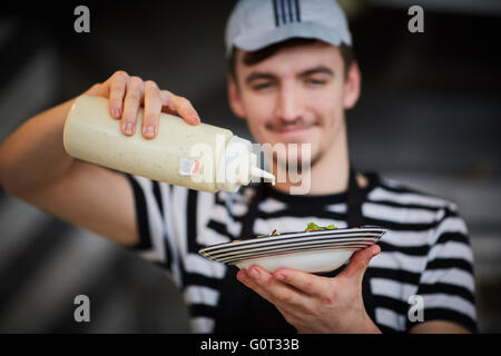 Pizza Express porte liverpool pizzaexpress chef making dégoulinant de sauce pour salade en ajoutant le détail la lumière de l'engraissement pl Banque D'Images