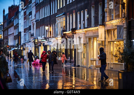 Rue de Londres la nuit et la pluie humide soir shopper walking Banque D'Images