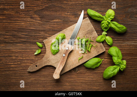 Feuilles de basilic frais sur fond de bois de près. Banque D'Images