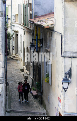 Deux personnes marchant par une étroite ruelle de la vieille ville d'Arles. France Banque D'Images
