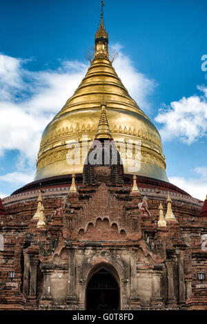 [Pagode Dhammayazika] BAGAN, MYANMAR- la pagode Dhammayazika (également Dhamma-ya-ka Zedi) est un temple bouddhiste situé dans le village de Pwasaw, dans la partie sud de la plaine de Bagan, au Myanmar. Il a été construit en 1196 sous le règne du roi Narapatisithu. La pagode est de conception circulaire et est faite de brique. Ses trois terrasses contiennent des tuiles de terre cuite illustrant des scènes du Jataka, et il est maintenant converti avec un grand dôme de parapluie doré. Banque D'Images