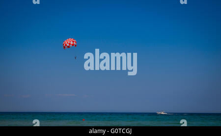Parachutiste et parachute coloré sur fond de ciel bleu Banque D'Images