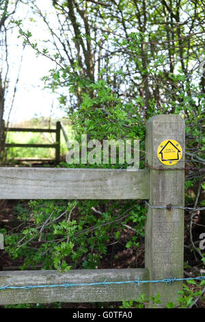 Stile sur un sentier public complet avec panneau jaune et de barbelés, Mai 2016 Banque D'Images