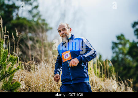 Un homme âgé s'exécutant sur l'athlète hill au cours d'un marathon de montagne Banque D'Images