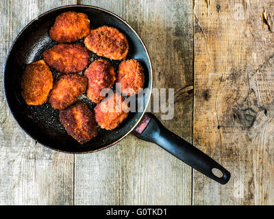 Escalopes de porc frit dans la chapelure dans une poêle Banque D'Images