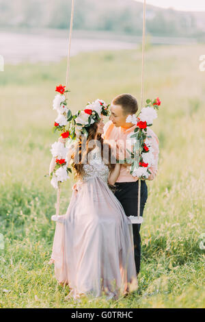 Belle image de l'amour en couple embracing on tree swing à l'extérieur Banque D'Images