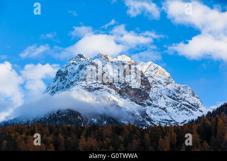 Vue imprenable sur le pic enneigé au-dessus de forêts colorées en Engadine, dans le canton de Grisons, Suisse Banque D'Images