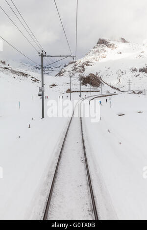 Ski personnes le long des voies des Grisons en Bernina Express (Graubuden) sis à Alpes, Suisse Banque D'Images